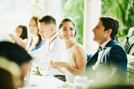 Couple de jeunes mariés pendant leur repas de mariage avec leurs convives