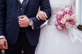 Une femme accrochée au bras de son mari le jour de leur mariage