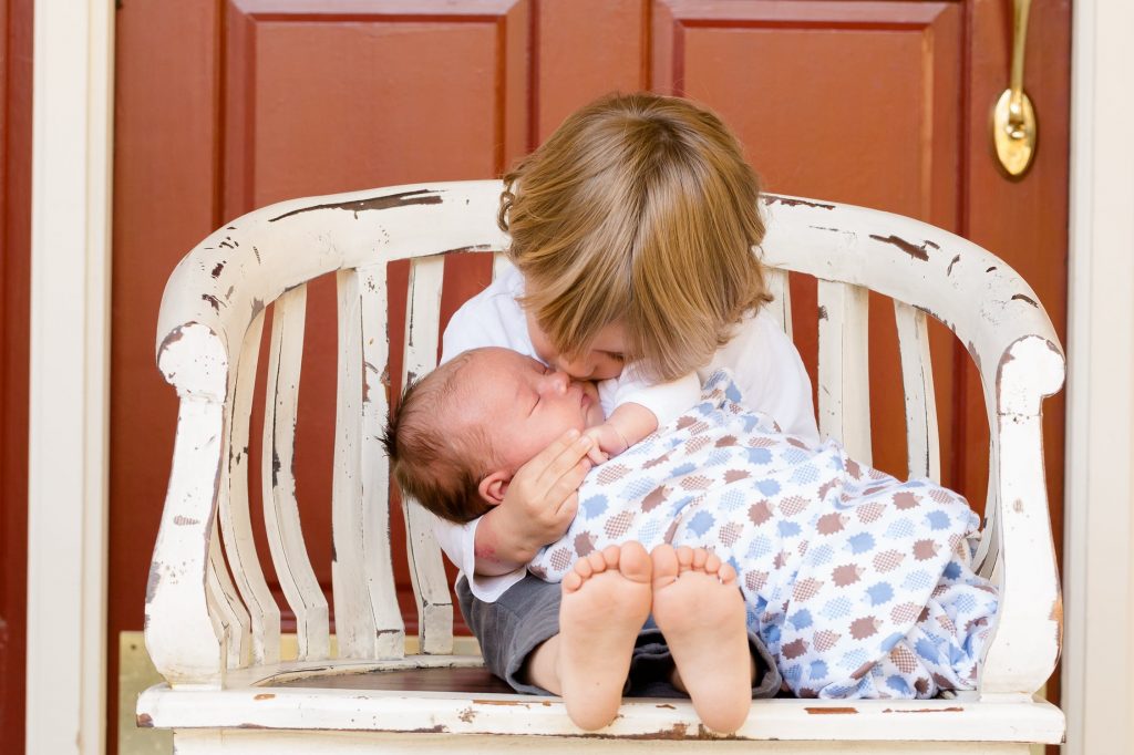 Grand frère qui fait un bisou à son petit frère