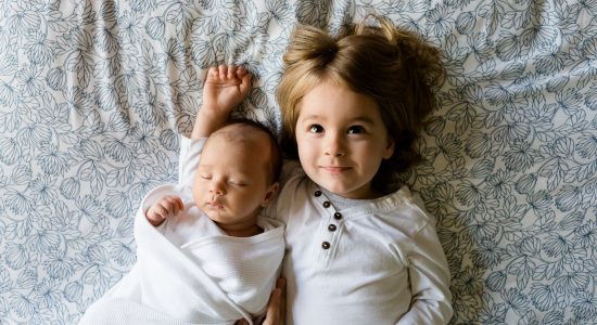 Bébé allongé à côté de son grand frère