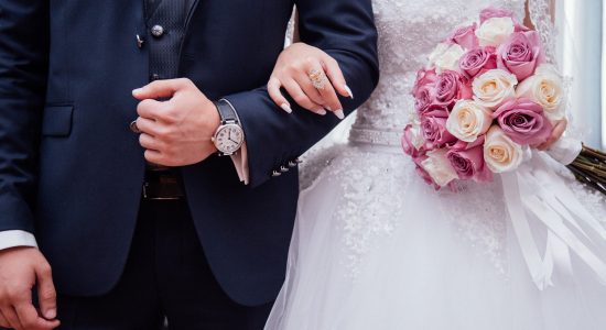 Une femme accrochée au bras de son mari le jour de leur mariage